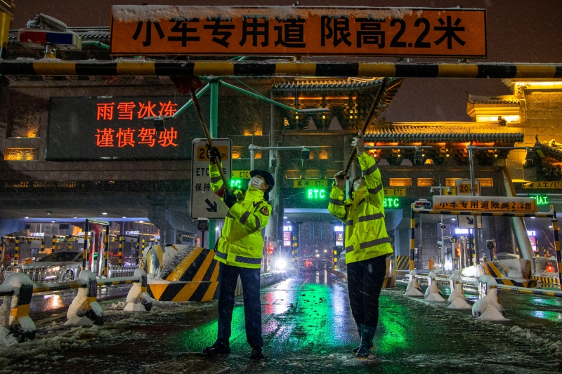 长沙收费站工作人员清除收费广场上的积雪  （周全摄）