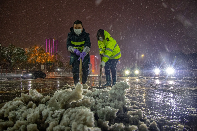 长沙收费站工作人员铲除收费广场上的积雪  （周全摄）